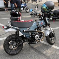 Pearl Gray Honda DAX 125 at a mini moto event with a red tartan plaid seat cover, white piping, handmade by Cheeky Seats