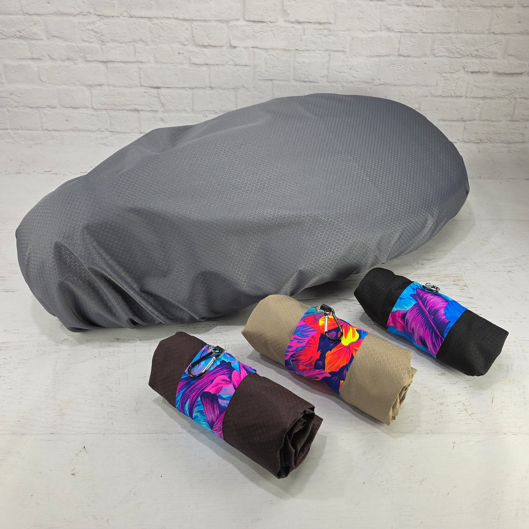 Gray honeycomb rain cover fitted over a Piaggio Fly or Liberty seat with bronze, tan and black carry pouches by Cheeky Seats
