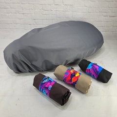 Gray honeycomb rain cover fitted over a Piaggio Fly or Liberty seat with bronze, tan and black carry pouches by Cheeky Seats